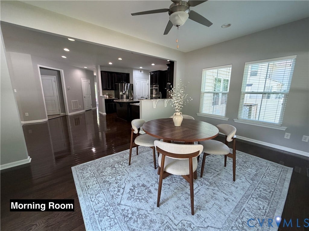Open-concept space featuring dark wood-finish flooring, recessed lighting, a ceiling fan, and large windows with horizontal blinds