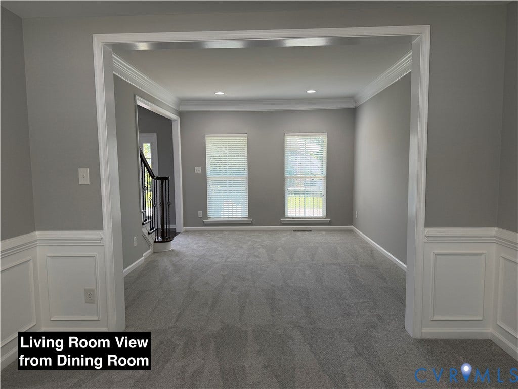 Neutral-toned interior featuring detailed white wainscoting, crown molding, recessed lighting, and high-pile wall-to-wall carpeting