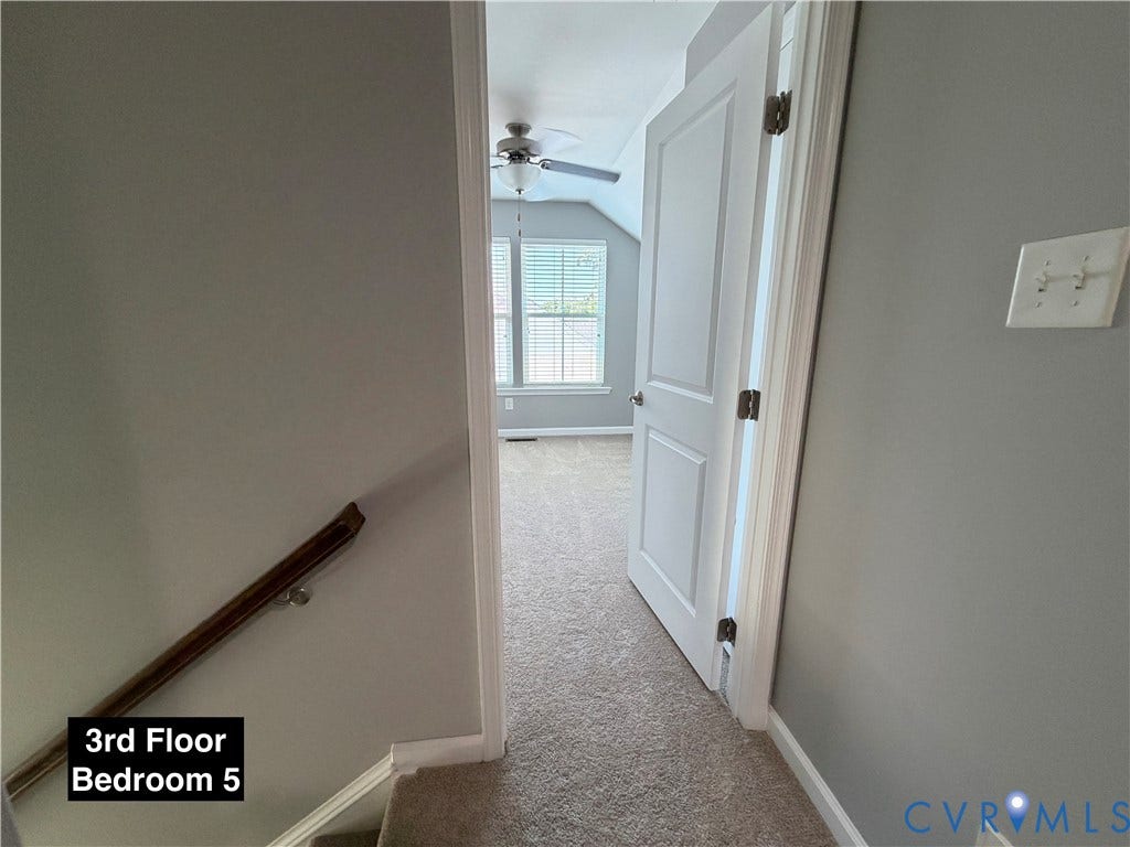 Neutral-toned room featuring wall-to-wall carpeting, dual-pane windows, and a ceiling fan with integrated lighting
