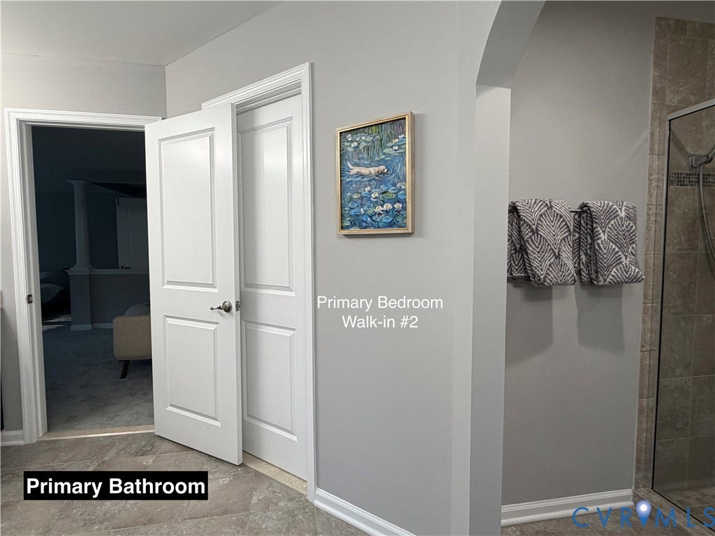 Neutral-toned interior featuring multi-panel white doors, tile flooring, and a glass-enclosed shower with tiled walls