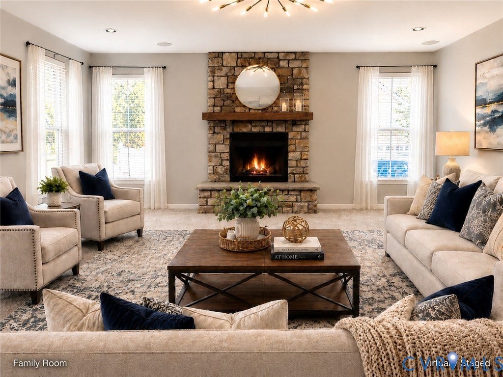 Spacious family room with a striking stone fireplace as the focal point, abundant natural light from multiple windows, and an open layout ideal for gathering and entertaining.
