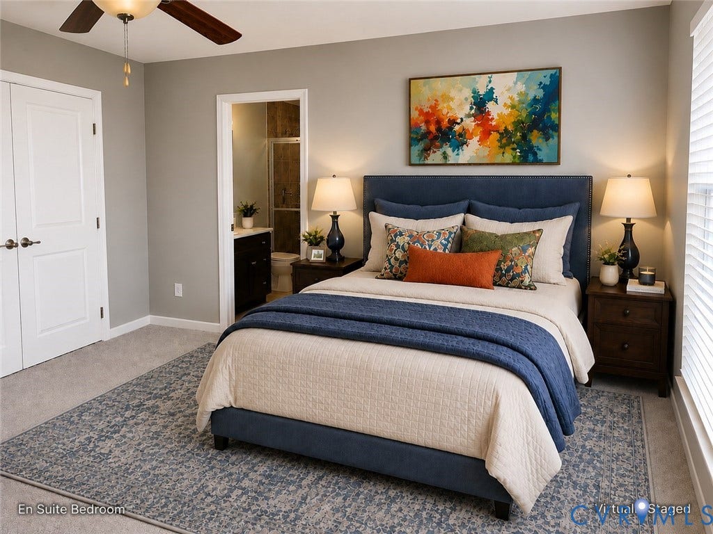 En suite bedroom featuring neutral wall finishes, carpeted flooring, a ceiling fan, abundant natural light from the large window, and direct access to the adjoining private bathroom
