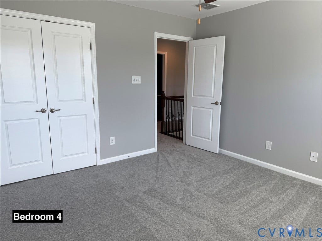 Neutral-toned interior featuring wall-to-wall carpeting, double-panel closet doors, and solid-core interior doors