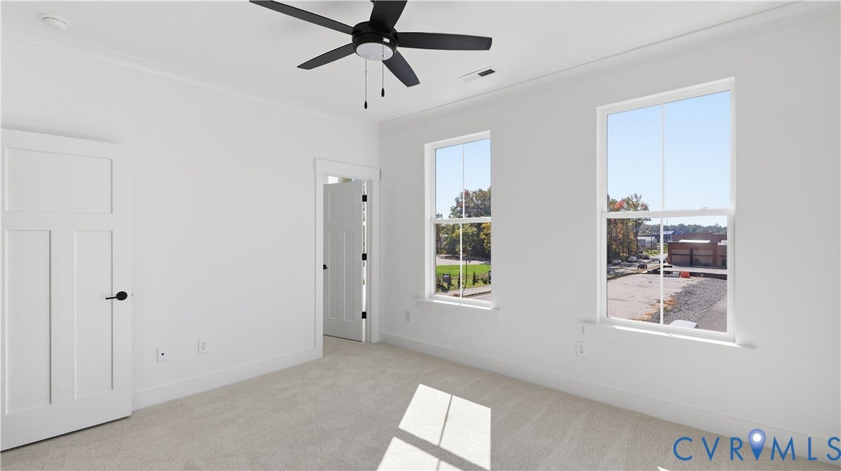 11612 Switch Drive, Midlothian Depot, Midlothian, VA 23113 Neutral-toned room featuring neutral carpeting, double-hung windows, a multi-blade ceiling fan with integrated lighting, and solid-core paneled doors with matte black hardware