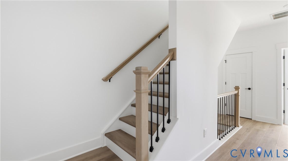 11612 Switch Drive, Midlothian Depot, Midlothian, VA 23113 Staircase featuring wood-finish treads, a square newel post, a natural wood-finish handrail, and matte black metal balusters set against wood-finish flooring