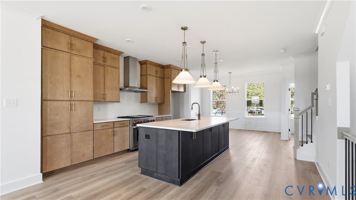 11612 Switch Drive, Midlothian Depot, Midlothian, VA 23113 Kitchen featuring wood-finish cabinetry, a central island with a contrasting dark base and light countertop, stainless steel range with a professional-style hood, pendant lighting, and wood-finish flooring