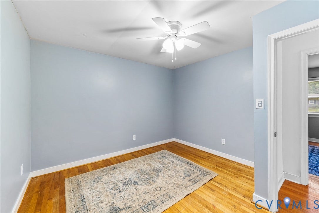 Interior space featuring wood-finish flooring and a ceiling-mounted light fixture with integrated fan
