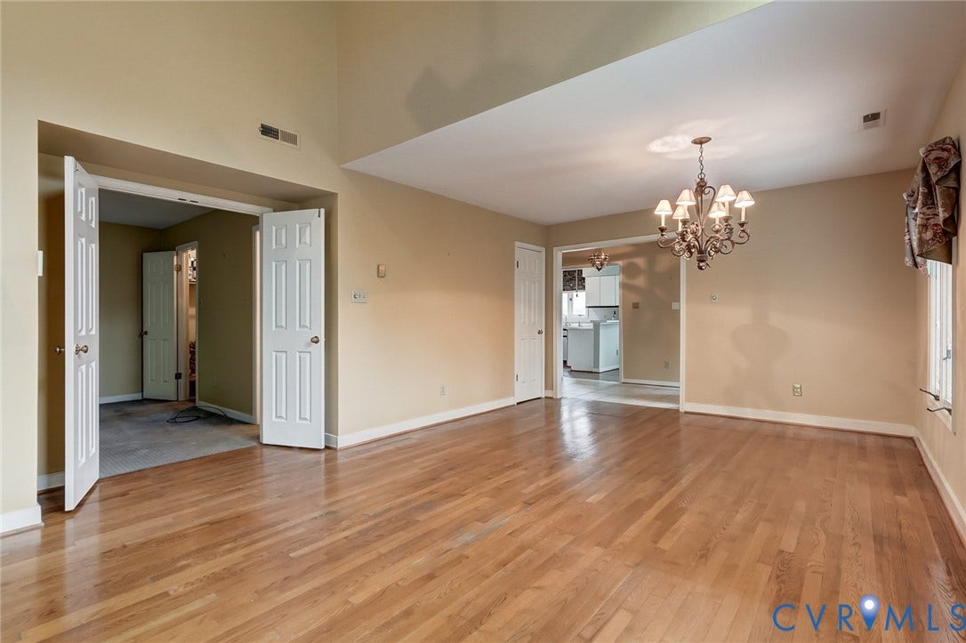 1109 Lakeland Circle, Henrico, VA 23229 Open-concept room featuring a vaulted ceiling, wood-finish flooring, and an ornate multi-arm chandelier