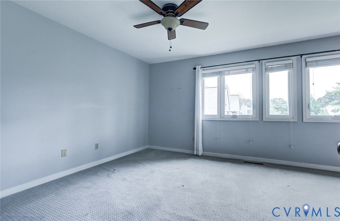 1109 Lakeland Circle, Henrico, VA 23229 Spacious room featuring neutral carpeting, triple-window configuration, and a ceiling fan with integrated lighting