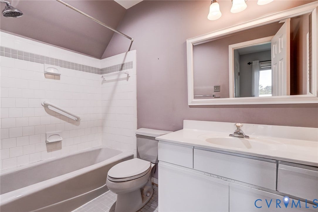 1109 Lakeland Circle, Henrico, VA 23229 Bathroom featuring a white vanity with an integrated basin, framed wall mirror, three-light fixture, and a tub-shower combination with white wall tile