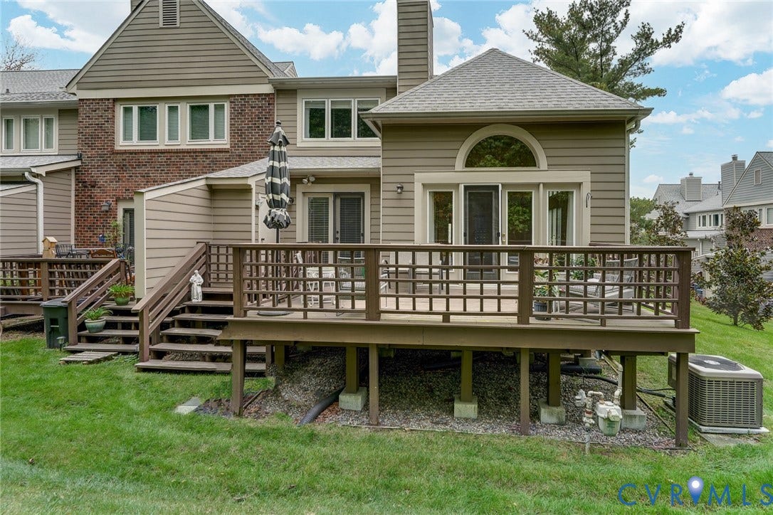 1109 Lakeland Circle, Henrico, VA 23229 Exterior elevation featuring horizontal siding and brick masonry, an expansive raised wood deck with integrated railings, and arched window detailing