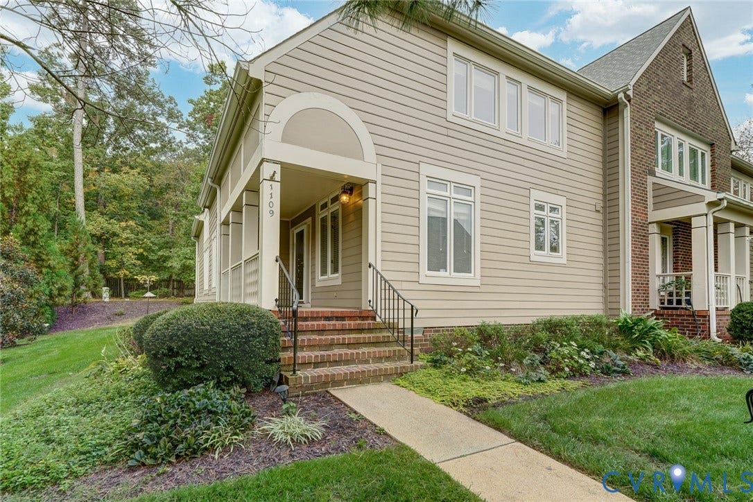 1109 Lakeland Circle, Henrico, VA 23229 Multi-story exterior featuring a mix of brick and horizontal siding, covered front entryway, arched architectural detail, decorative metal railing, and concrete walkway