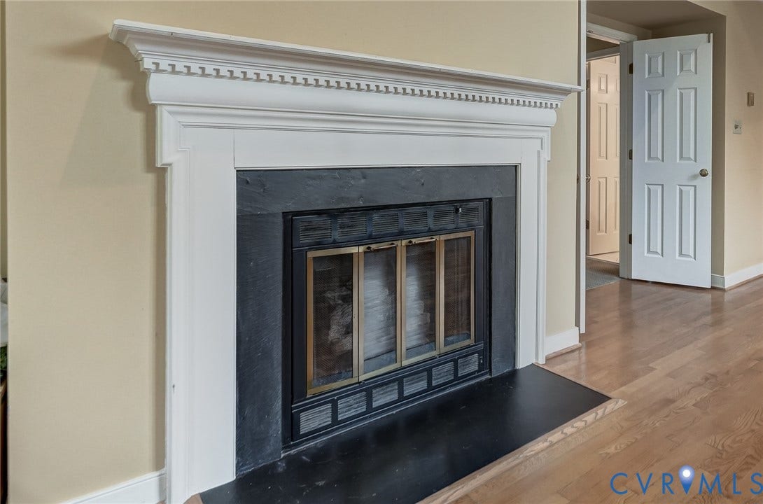 1109 Lakeland Circle, Henrico, VA 23229 Fireplace featuring a white decorative mantel, dark stone surround, black hearth, and wood-finish flooring