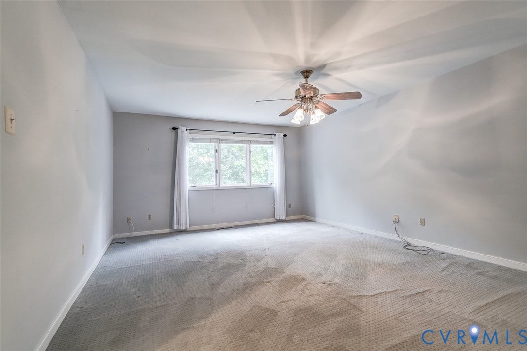 1109 Lakeland Circle, Henrico, VA 23229 Neutral-toned interior space featuring wall-to-wall carpeting, a multi-pane window with trim, and a ceiling-mounted light fixture with a central fan