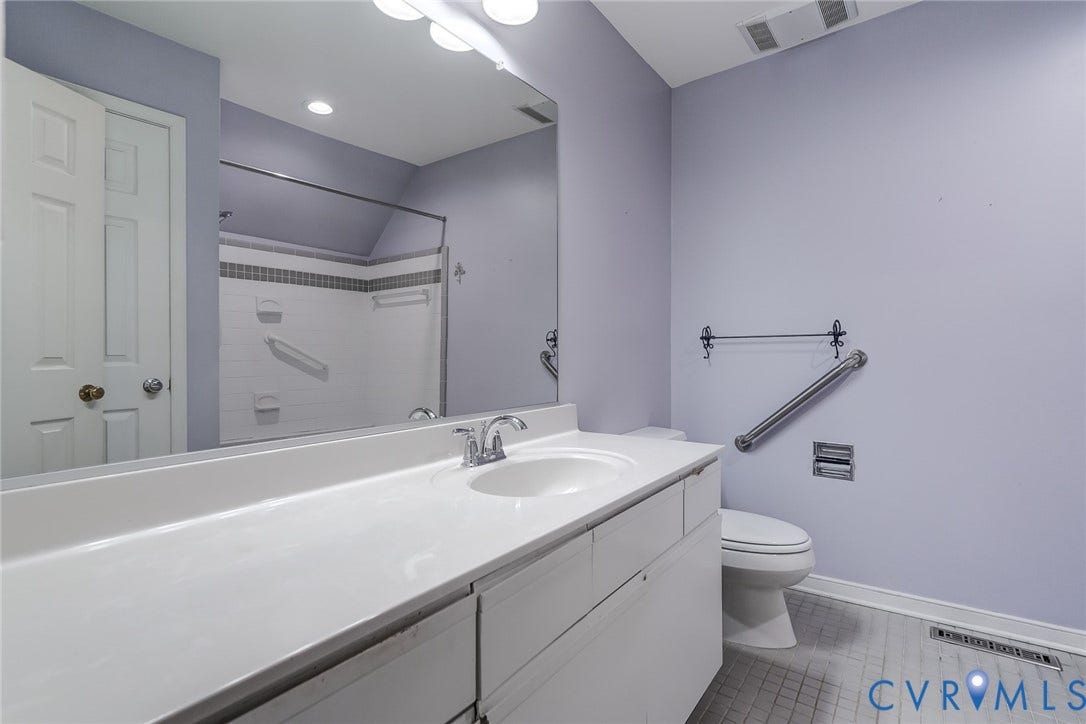1109 Lakeland Circle, Henrico, VA 23229 Full-width vanity with a solid-surface countertop, integrated basin, large wall-mounted mirror, and tile flooring