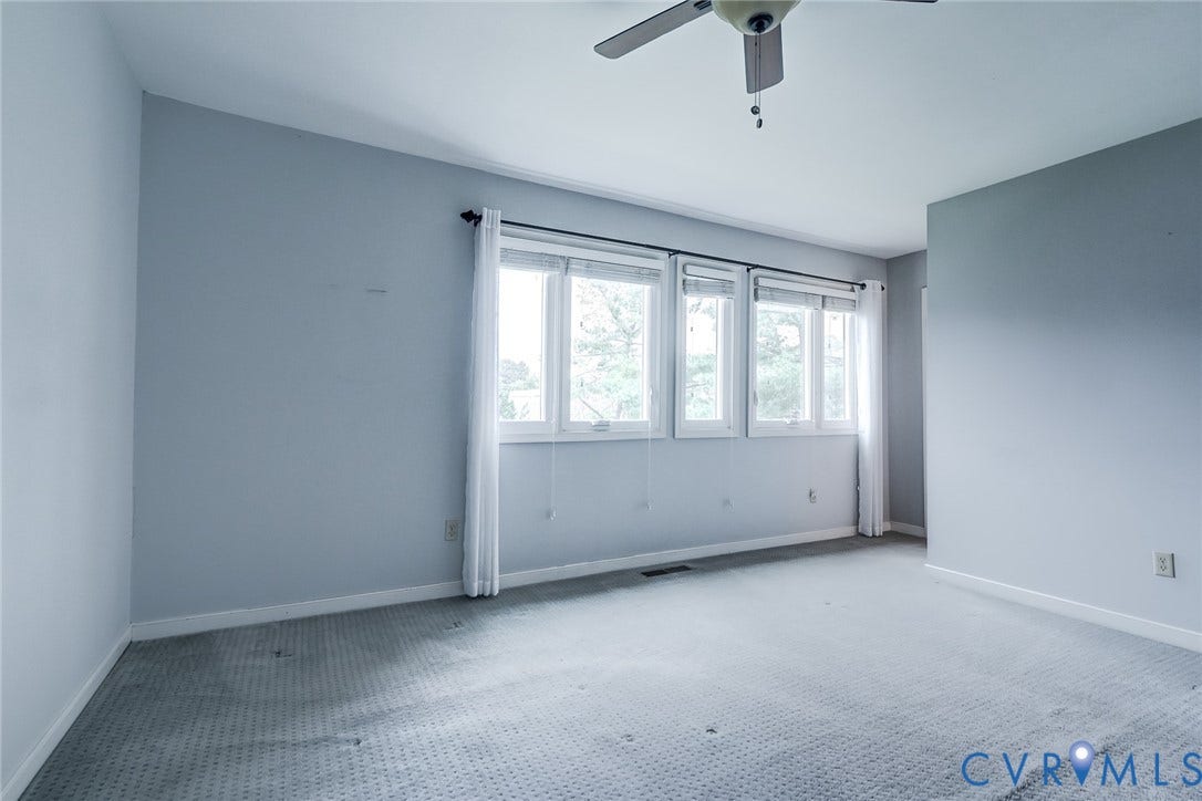 1109 Lakeland Circle, Henrico, VA 23229 Spacious room featuring neutral carpeting, triple-window configuration with white trim, and a ceiling-mounted fan