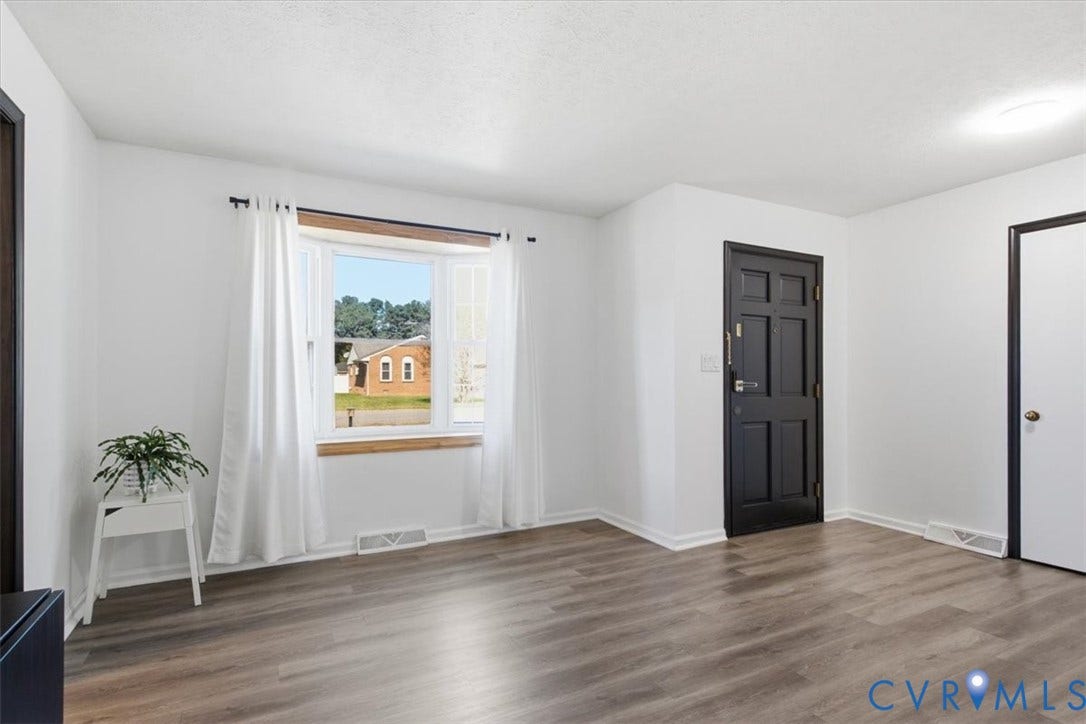 2609 Maury Road, Prince George, VA 23805 Interior space featuring wood-finish flooring, a multi-pane bay window, and a paneled entry door with contrasting trim