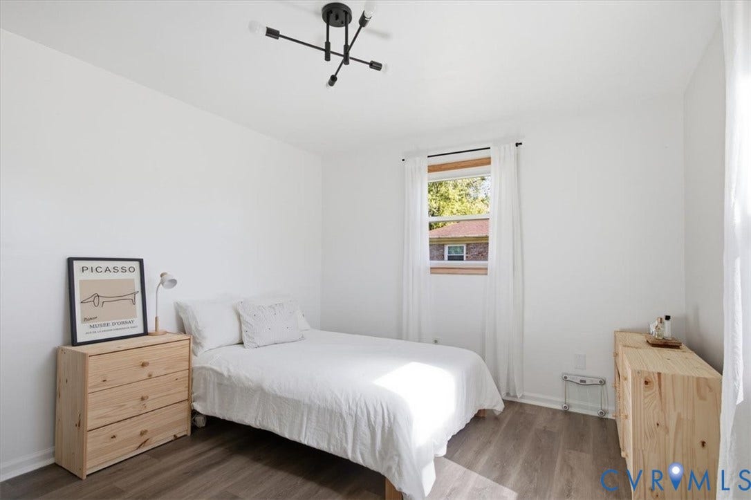2609 Maury Road, Prince George, VA 23805 Bedroom featuring wood-finish flooring, a matte black multi-arm light fixture, and a single-hung window with a natural wood frame
