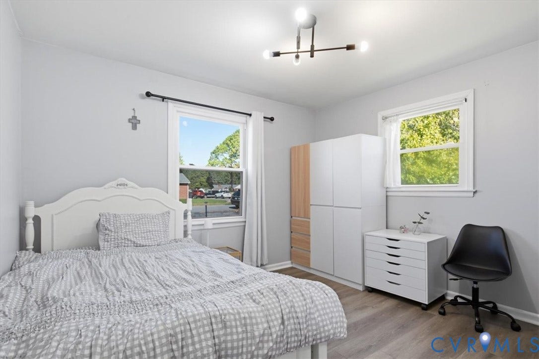 2609 Maury Road, Prince George, VA 23805 Neutral-toned interior featuring wood-finish flooring, dual windows with white casing, and a contemporary multi-arm sputnik chandelier
