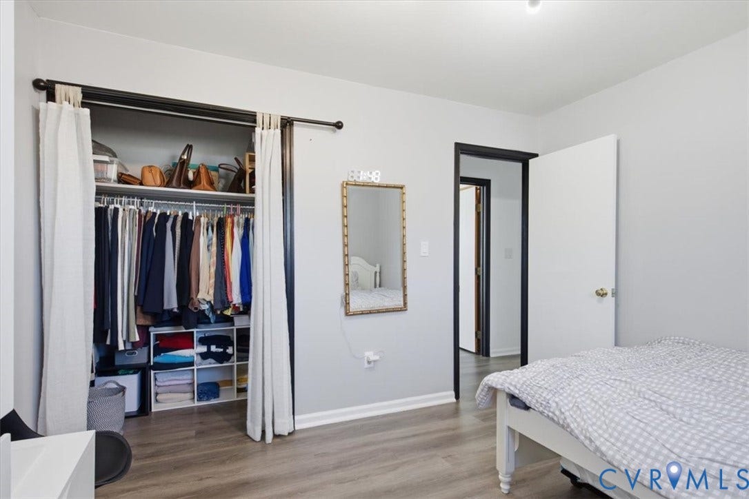 2609 Maury Road, Prince George, VA 23805 Room featuring wood-finish flooring, a sliding bypass closet track with wall-mounted rod, and contrasting black door frames
