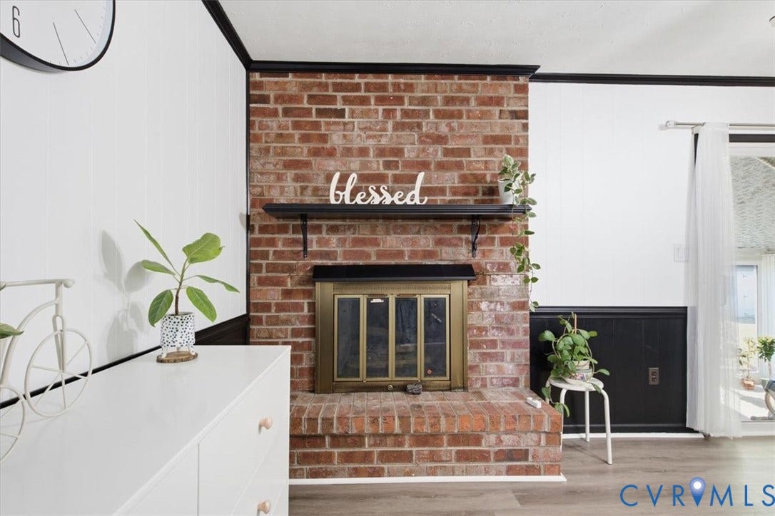 2609 Maury Road, Prince George, VA 23805 Floor-to-ceiling red brick fireplace with a built-in hearth, metal fire screen, and fixed black mantle