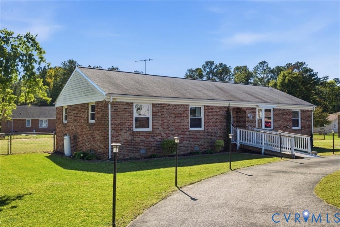 2609 Maury Road, Prince George, VA 23805 Ranch-style brick exterior featuring a gable roof, vinyl siding accents, and a paved driveway with an integrated wheelchair-accessible ramp