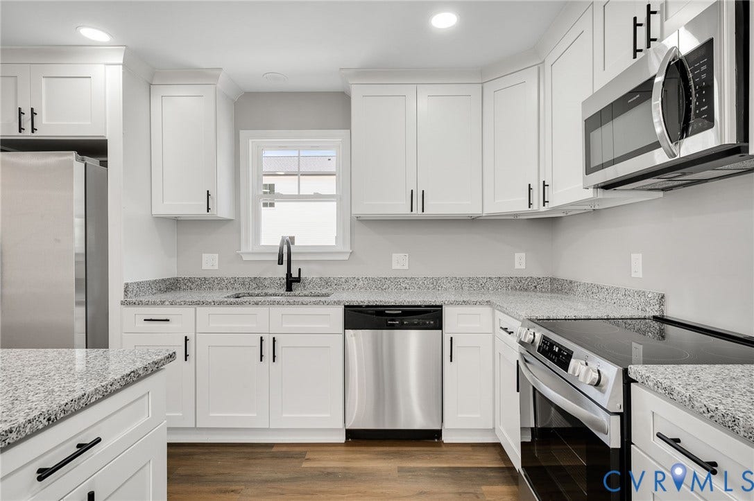 914 Diamond Street, Petersburg, VA 23803 Kitchen featuring white Shaker-style cabinetry, stone-finish countertops, stainless steel appliances, matte black hardware, and wood-finish flooring