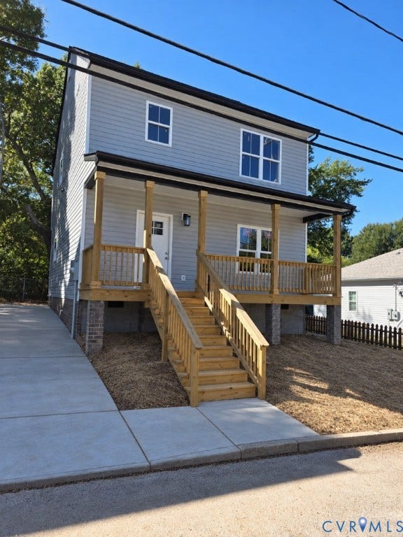914 Diamond Street, Petersburg, VA 23803 Two-story residence featuring light grey horizontal siding, a covered wooden front porch with railings, and a concrete driveway