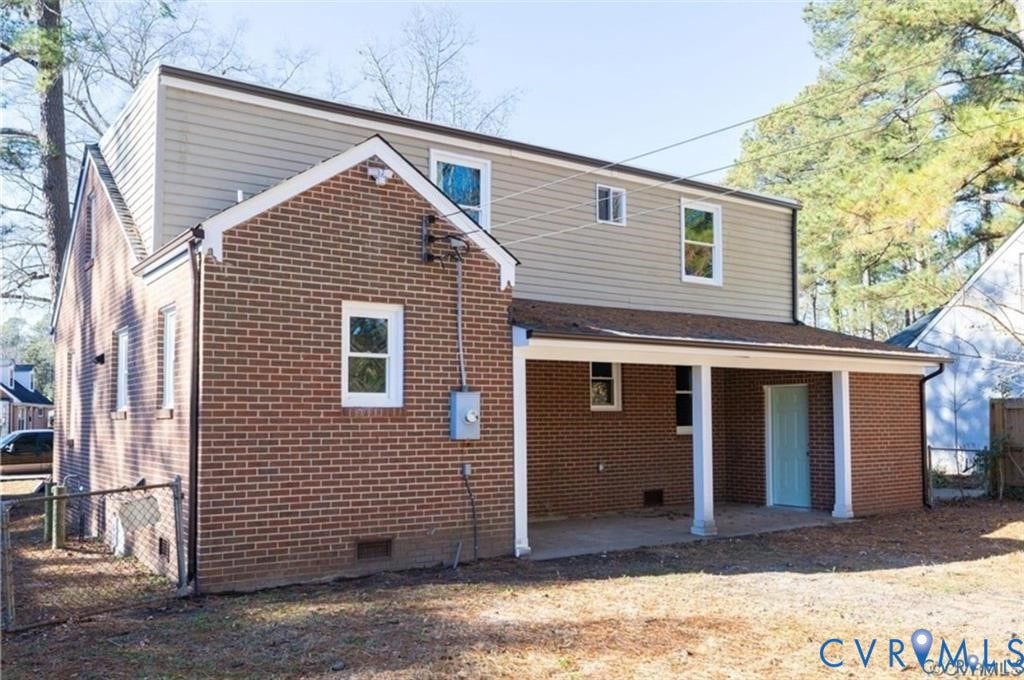 Two-story exterior featuring a brick masonry lower level, horizontal siding upper level, and a covered patio supported by structural columns
