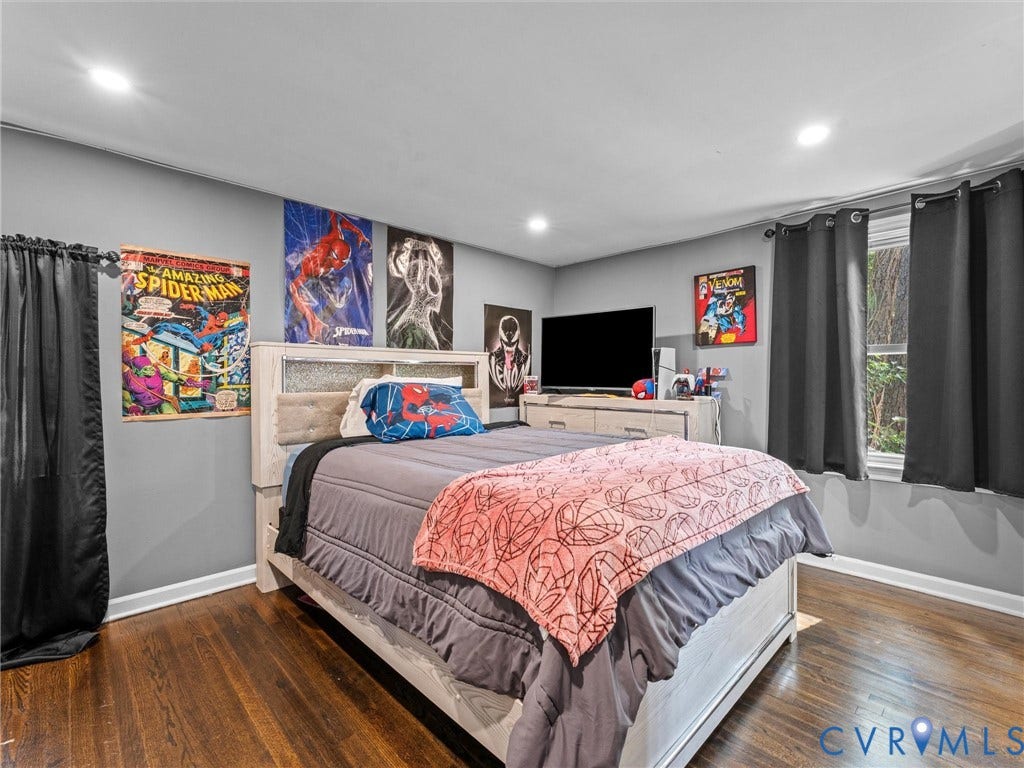 Bedroom featuring dark-stained wood-finish flooring, recessed lighting, and dual windows with window hardware