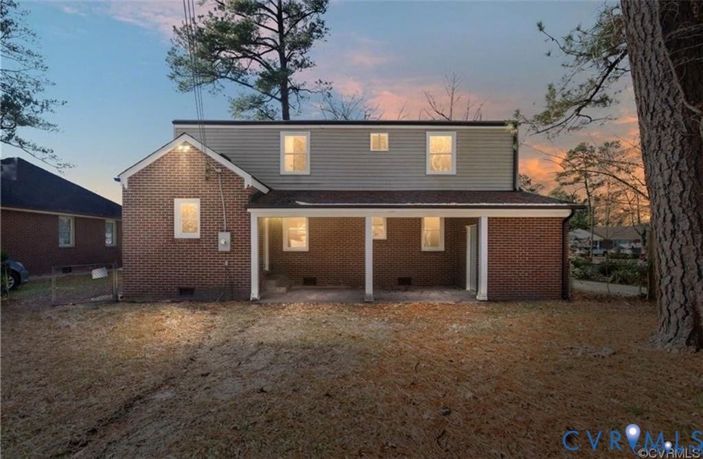 Exterior featuring brick and siding construction, covered concrete patio, and multiple windows