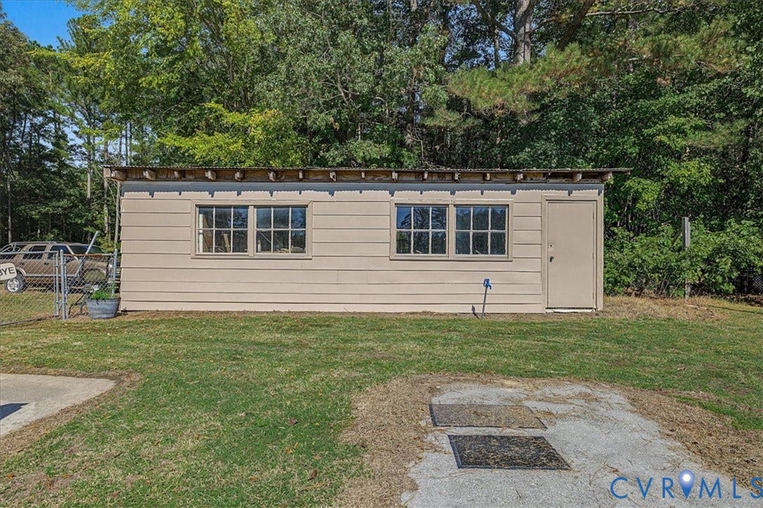 14421 Alden Road, Disputanta, VA 23842 Detached outbuilding featuring horizontal lap siding, a metal shed roof, multi-pane windows, and a solid-panel entry door