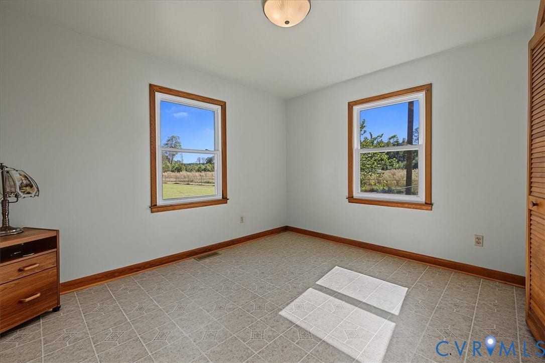 14421 Alden Road, Disputanta, VA 23842 Room featuring tile flooring, dual windows with wood trim, neutral wall paint, and louvered closet doors