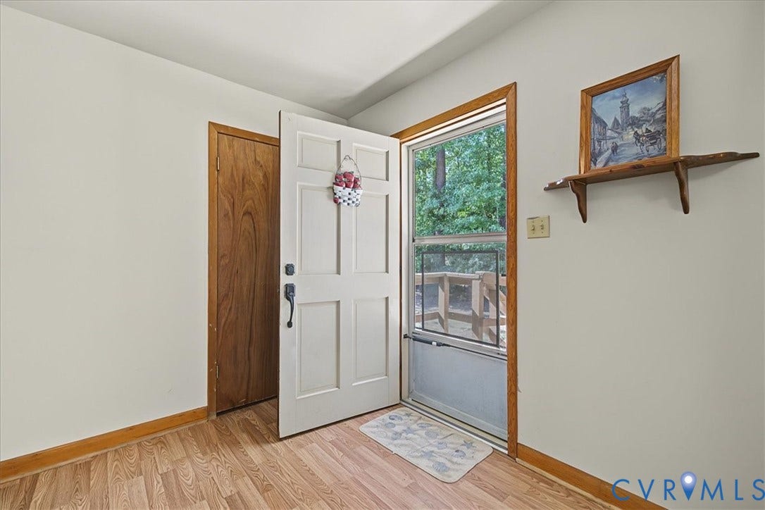 14421 Alden Road, Disputanta, VA 23842 Entryway featuring a six-panel door, wood-finish flooring, wood door casing, and a storm door