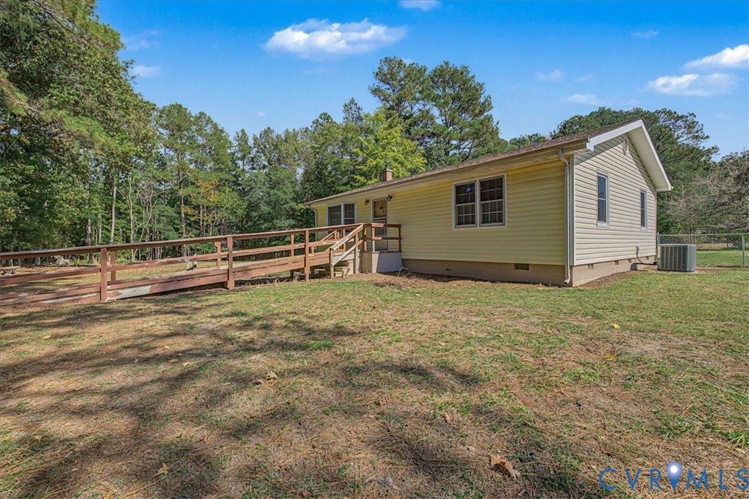 14421 Alden Road, Disputanta, VA 23842 Single-story residence featuring vinyl siding, a wooden access ramp, double-pane windows, and a generous lot with mature perimeter trees