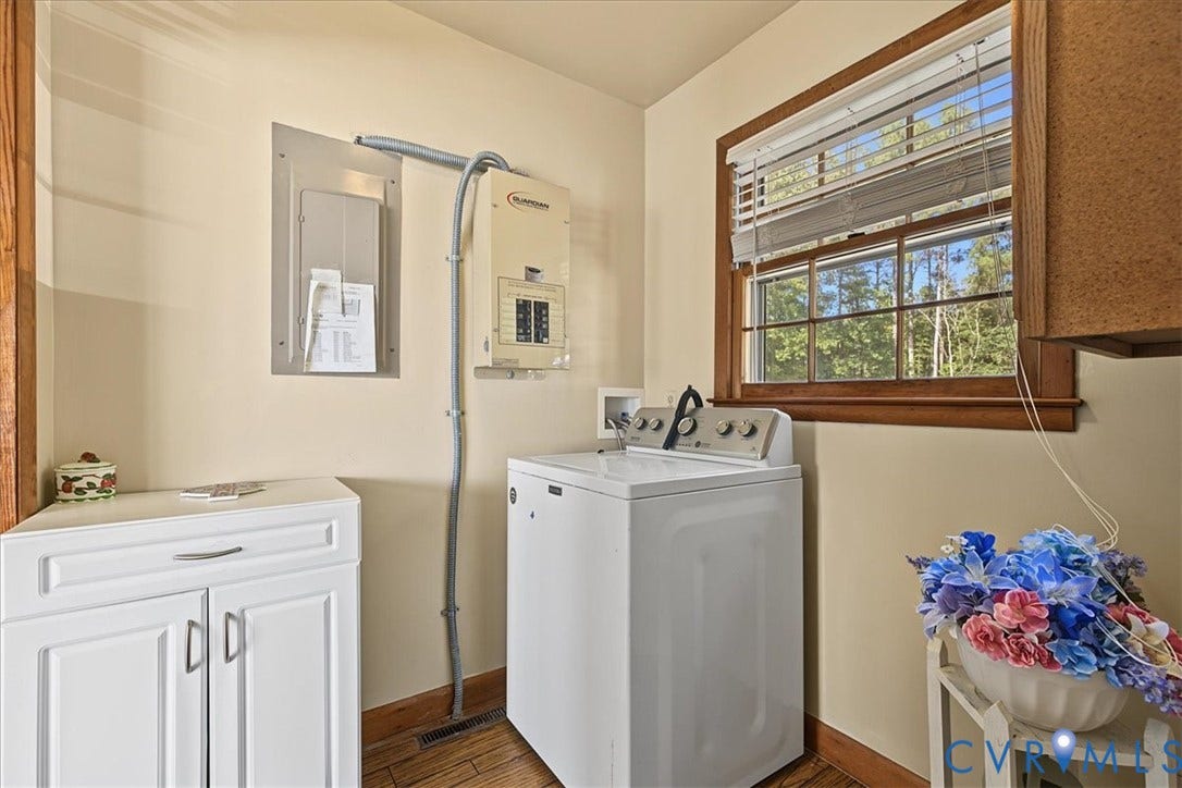 14421 Alden Road, Disputanta, VA 23842 Laundry space featuring white shaker-style cabinetry, wood-finish flooring, a wood-trimmed window, and wall-mounted electrical components