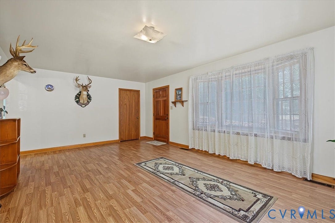 14421 Alden Road, Disputanta, VA 23842 Large multi-pane window, wood-finish flooring, solid wood entrance door, and square flush-mount ceiling light fixture