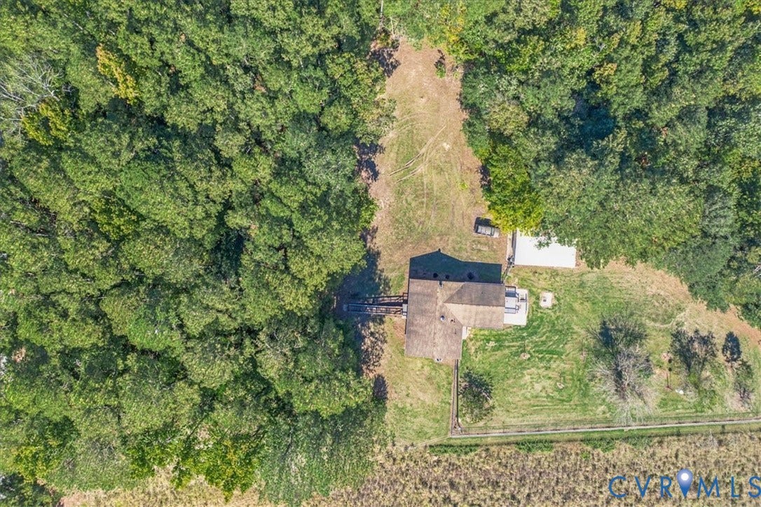 14421 Alden Road, Disputanta, VA 23842 Aerial view featuring a multi-story residence, expansive wooded acreage, a detached outbuilding, and fenced pasture land