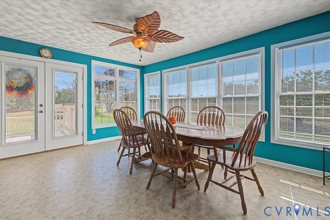14421 Alden Road, Disputanta, VA 23842 Sunroom featuring multi-pane glass doors, expansive windows with blinds, textured ceiling, and a decorative leaf-style ceiling fan