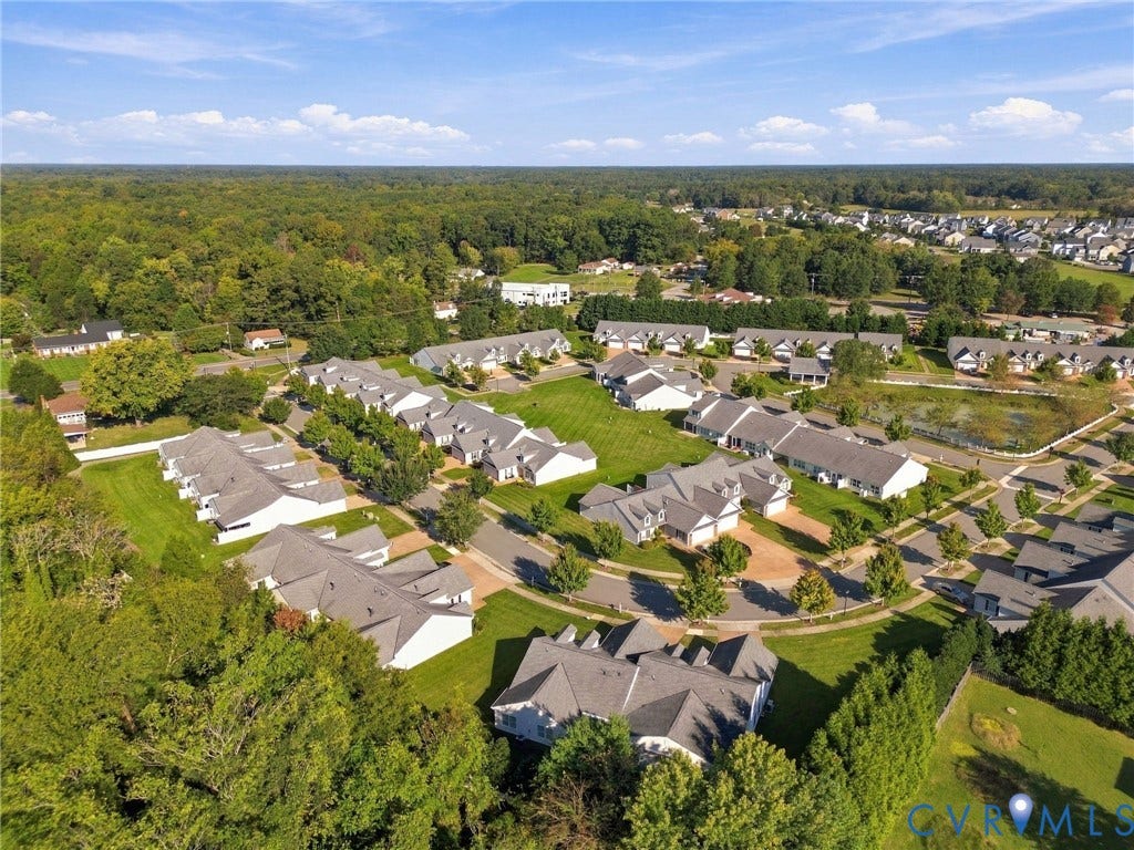 8146 Janice Avenue, Mechanicsville, VA 23111 Aerial perspective of a multi-unit residential community featuring peaked rooflines, expansive manicured green spaces, mature tree buffers, and winding asphalt roadways