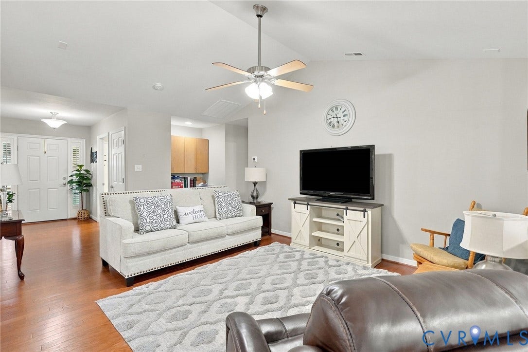 8146 Janice Avenue, Mechanicsville, VA 23111 Living area featuring vaulted ceilings, wood-finish flooring, and a multi-blade ceiling fan with integrated lighting