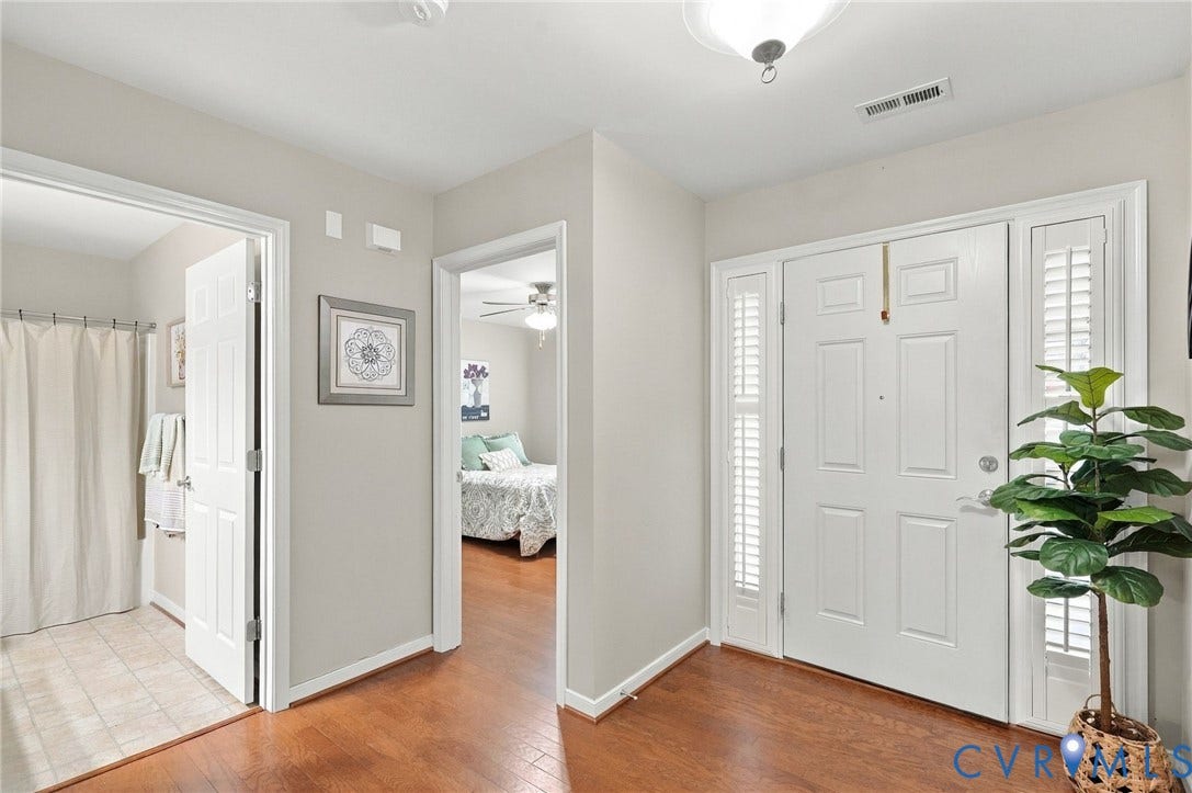 8146 Janice Avenue, Mechanicsville, VA 23111 Entryway featuring wood-finish flooring, a six-panel front door with sidelights, and neutral wall paint