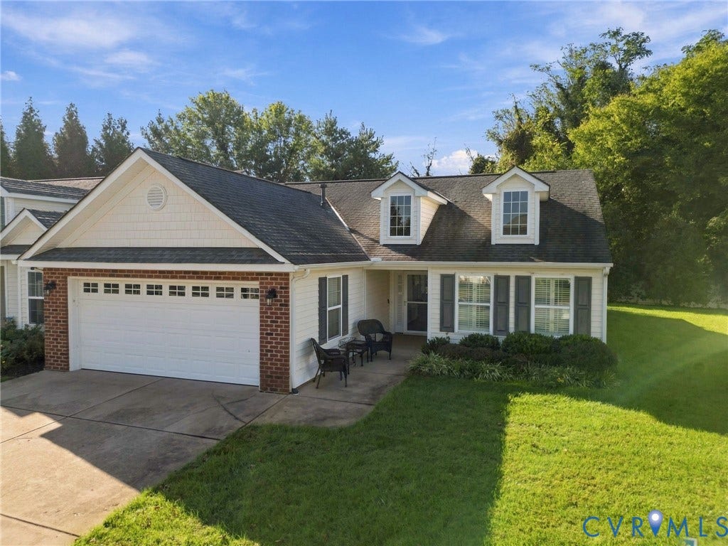 8146 Janice Avenue, Mechanicsville, VA 23111 Exterior featuring a brick and siding facade, attached two-car garage, dormer windows, shutter-accented windows, and a paved driveway