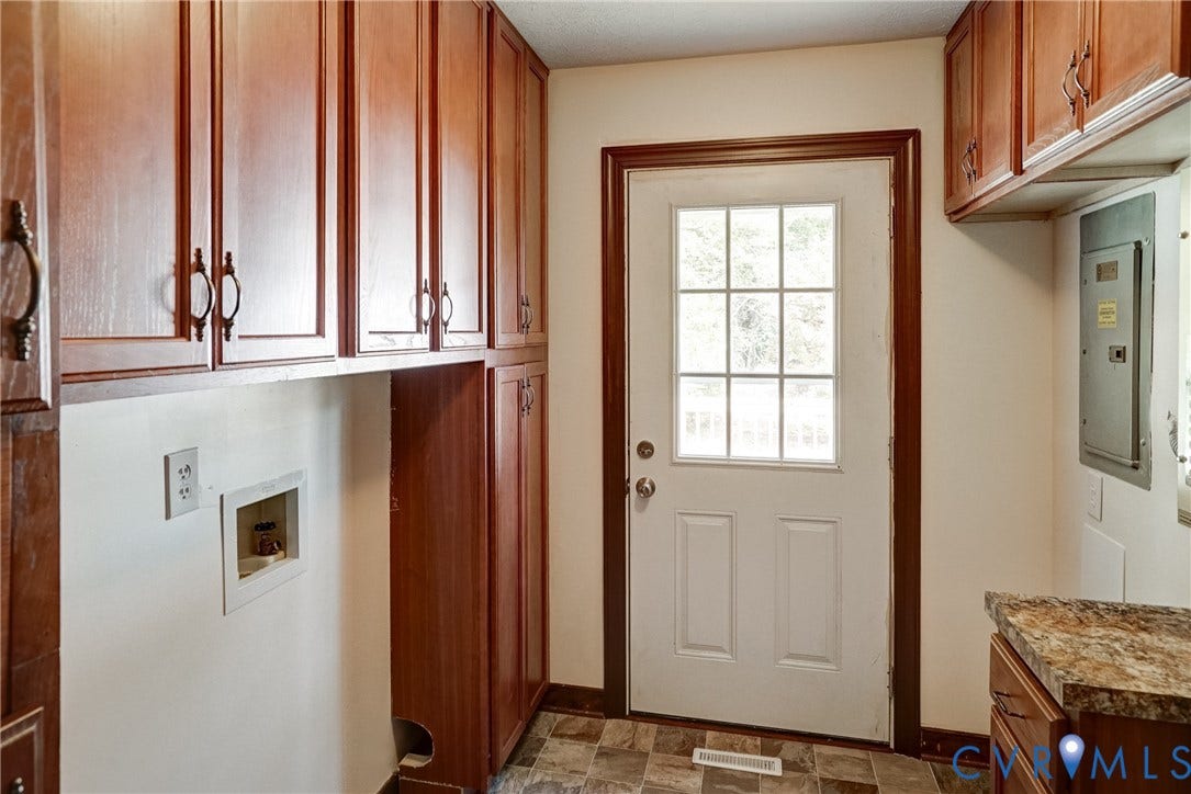 4130 Charles City Road, Charles City, VA 23231 Utility room featuring stained wood cabinetry, stone-finish countertops, tiled flooring, and an exterior door with a multi-pane glass insert