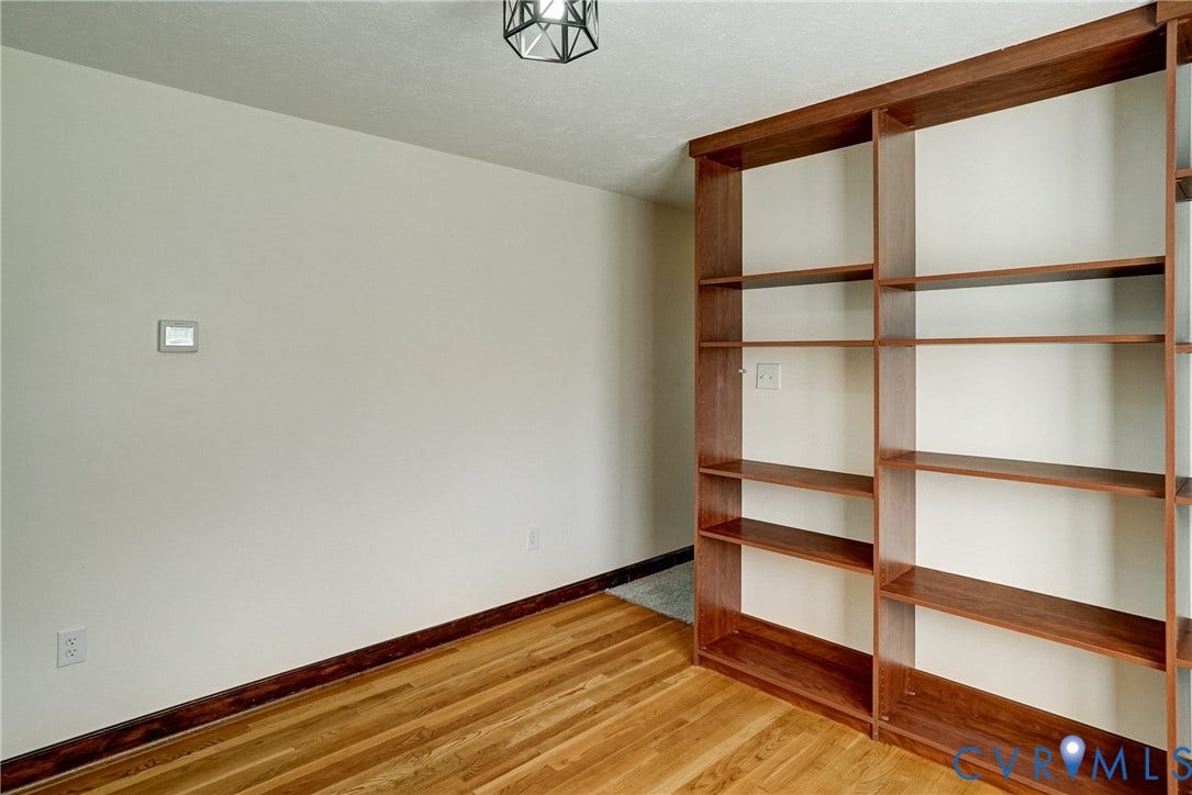 4130 Charles City Road, Charles City, VA 23231 Floor-to-ceiling built-in wooden shelving, hardwood flooring, and geometric pendant lighting