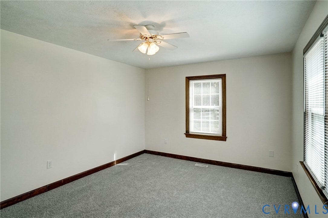 4130 Charles City Road, Charles City, VA 23231 Neutral-toned carpet, multi-pane windows with wood-finish trim, and a central ceiling fan with integrated lighting