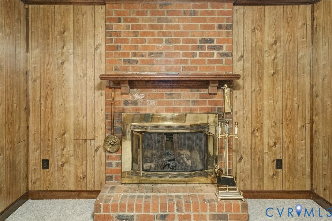 4130 Charles City Road, Charles City, VA 23231 Floor-to-ceiling brick fireplace surround, wood-finish mantel, and vertical wood wall paneling