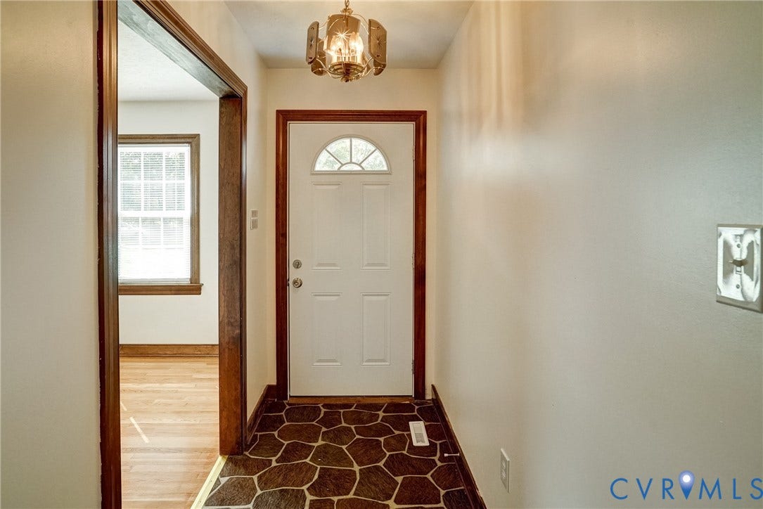 4130 Charles City Road, Charles City, VA 23231 Foyer featuring flagstone-style tile flooring, a multi-paneled front door with a semicircular transom window, and a multi-light metal chandelier