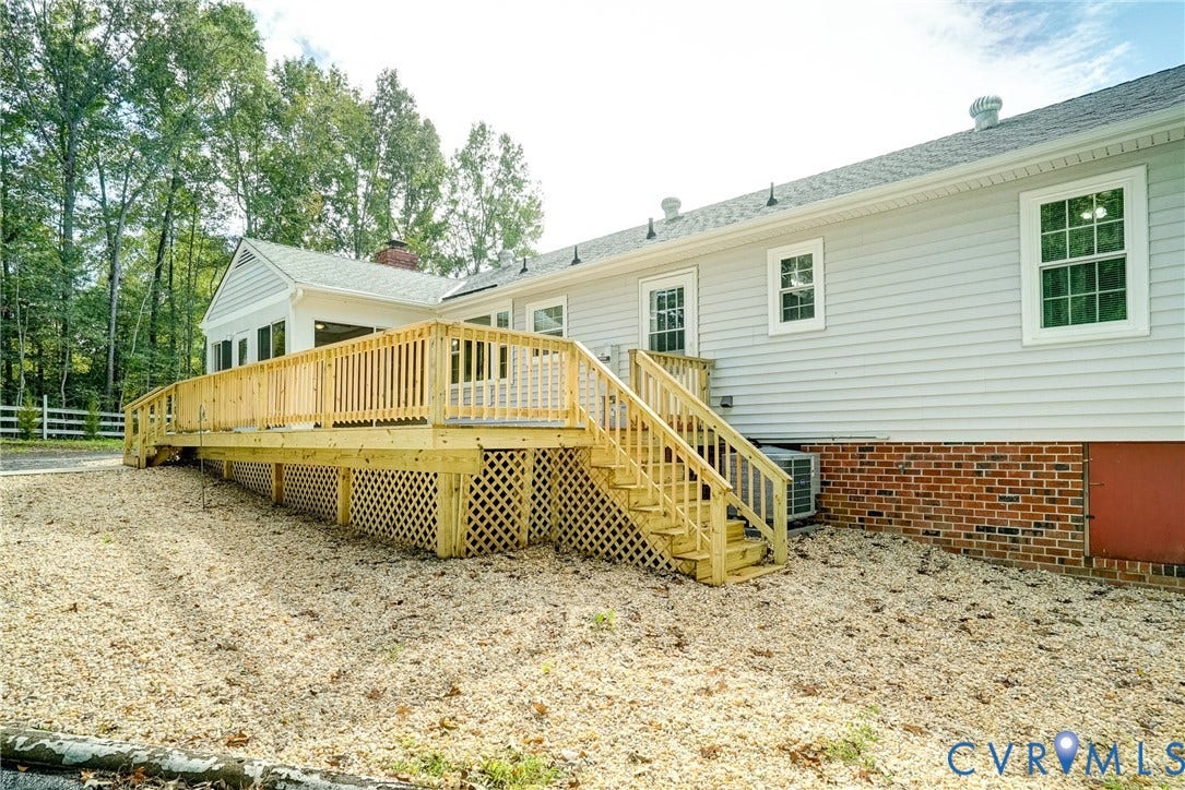 4130 Charles City Road, Charles City, VA 23231 Exterior featuring light-colored horizontal siding, brick foundation, wood deck with lattice skirting, and white-trimmed windows