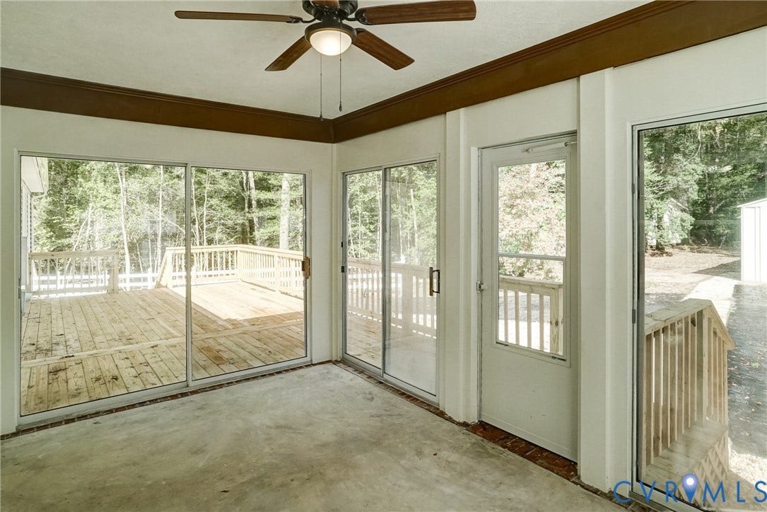 4130 Charles City Road, Charles City, VA 23231 Sunroom featuring concrete flooring, a ceiling fan with light fixture, multiple sliding glass doors, and direct access to an exterior wood deck